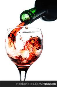 Red wine pouring in glass. Isolated over white. Focused on bottle.