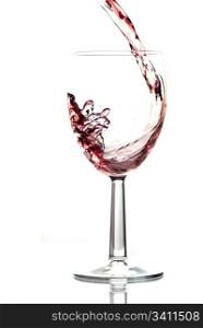 Red wine pouring into wine glass. White background, reflexion.