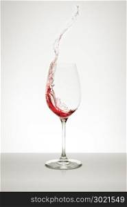 red wine splashing out of the glass