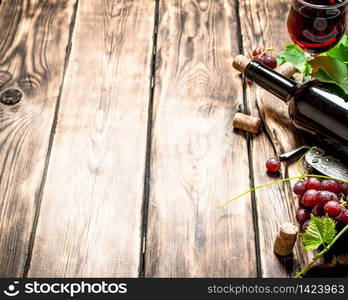 Red wine with a vine branch. On a wooden table.. Red wine with a vine branch.