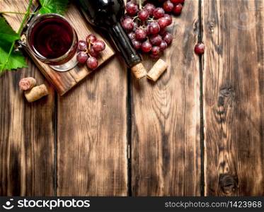 Red wine with a vine branch. On a wooden table.. Red wine with a vine branch.