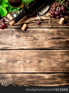 Red wine with a vine branch. On a wooden table.. Red wine with a vine branch.