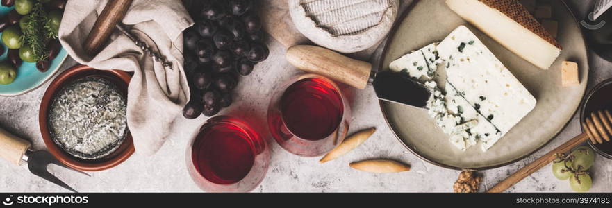 Red wine with charcuterie assortment on rustic concrete background, flat lay, copyspace