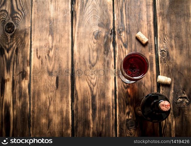 Red wine with corks. On wooden background.. Red wine with corks.