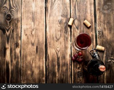Red wine with corks. On wooden background.. Red wine with corks.