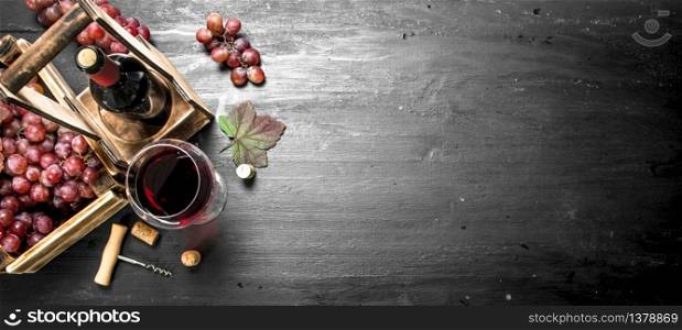Red wine with fresh grapes in a box. On the black chalkboard.. Red wine with fresh grapes in a box.