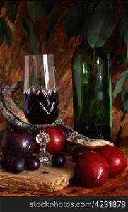 Red wine with fruits. A glass and bottle