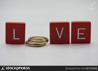 Red wooden letters with simple plain wedding bands.