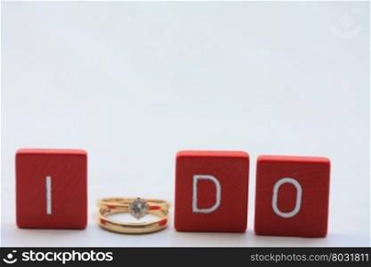 Red wooden letters with simple plain wedding bands.