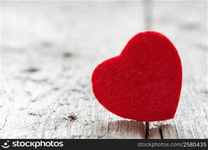 Red wool heart shape on grungy wooden floor