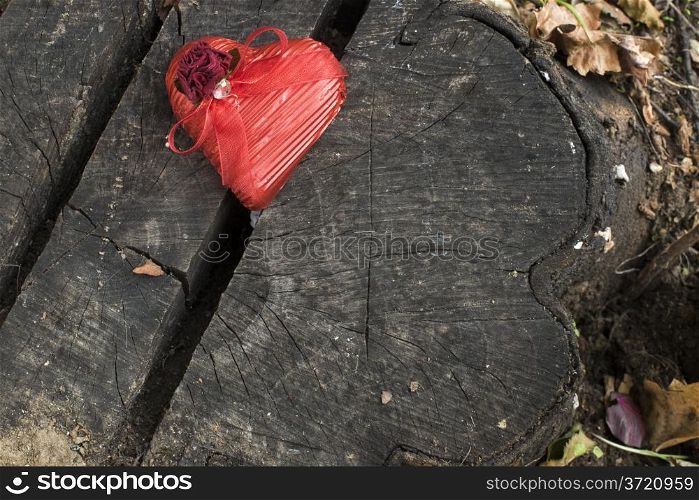 Red wrapped heart on wooden background