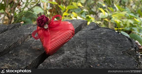 Red wrapped heart on wooden background