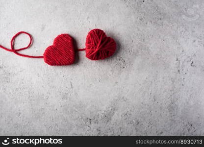 Red yarn heart shaped on the wall background