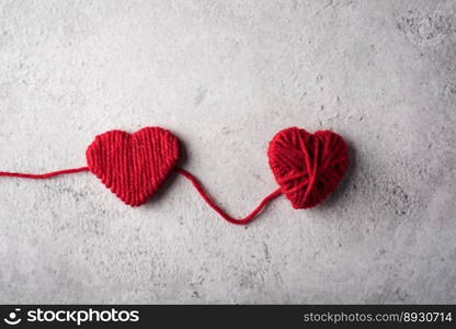 Red yarn heart shaped on the wall background