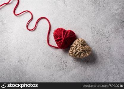 Red yarn heart shaped on the wall background