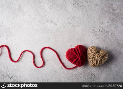 Red yarn heart shaped on the wall background