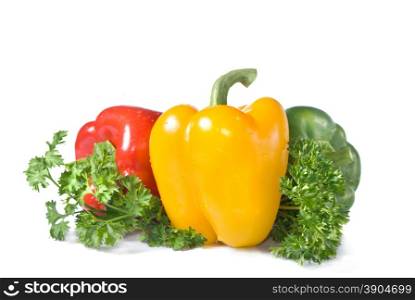 red, yellow and green pepper with parsley isolated on white