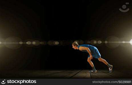 Reday to run. Young man athlete standing in start pose