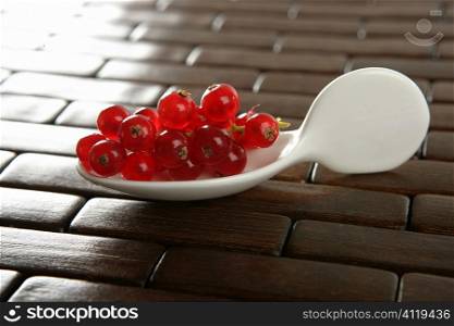 Redcurrant berries in a white spoon