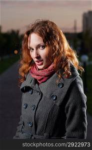 redhead 20s women outdoor, head and shoulders portrait, in autumn park, weared scarf and coat. Vertical shot.