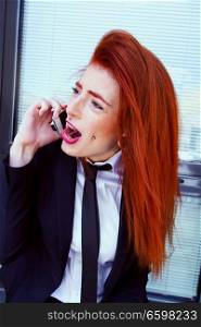 Redhead bussiness woman talking by her phone 