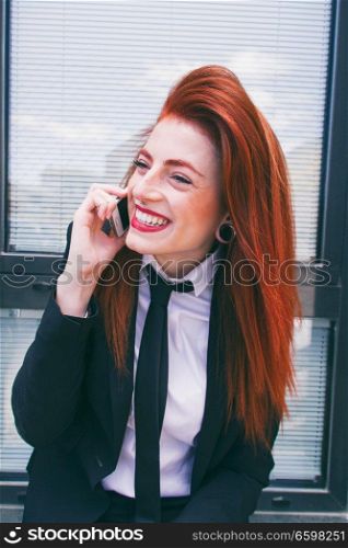 Redhead bussiness woman talking by her phone 