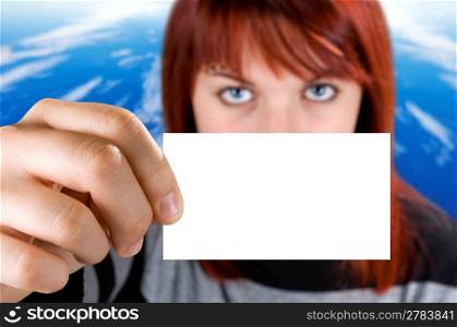 Redhead girl holding a business card on a nature background. Close-up of the hand with the empty card. Studio shot, composite.