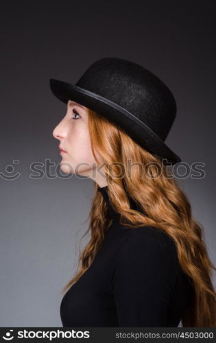 Redhead girl in hat against grey background