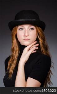 Redhead girl in hat against grey background
