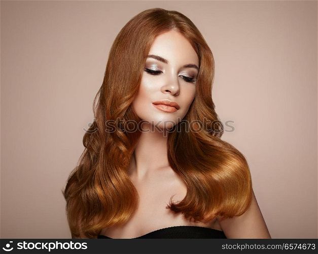 Redhead Girl with Long Healthy and Shiny Curly Hair. Care and Beauty. Beautiful Model Woman with Wavy Hairstyle. Make-Up and Black Dress