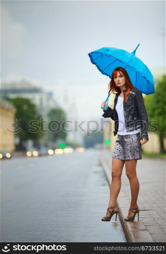 redhead girls with umbrella waiting a bus