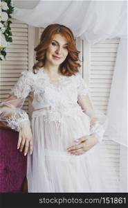 Redhead pregnant girl in a delicate situation.. Portrait of a redhead girl in a transparent negligee 6830.