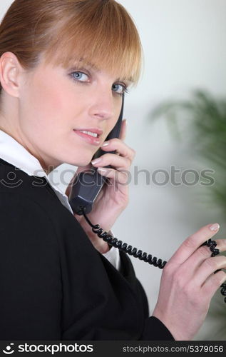 Redhead using an office telephone