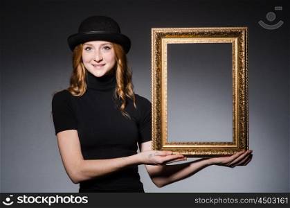 Redhead with picture frame against dark background