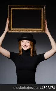 Redhead with picture frame against dark background