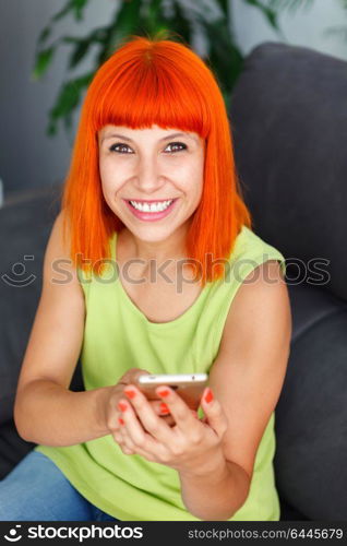 Redhead woman calling with her mobile at home