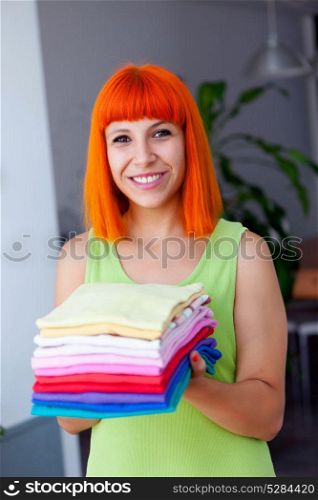 Redhead woman doing laundry with clothes folded and ironed