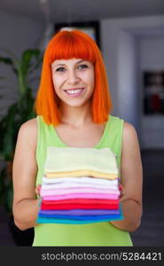 Redhead woman doing laundry with clothes folded and ironed