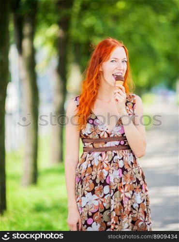 Redhead Woman eating ice-cream sunny day outdoors. woman eating ice-cream