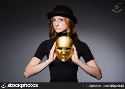 Redhead woman in hat iwith mask in hypocrisy consept against grey background