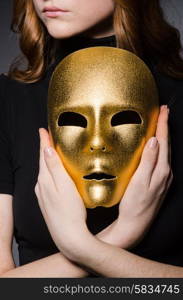 Redhead woman in hat iwith mask in hypocrisy consept against grey background