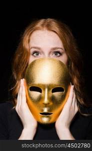 Redhead woman iwith mask in hypocrisy consept against black background