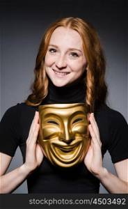 Redhead woman iwith mask in hypocrisy consept against grey background
