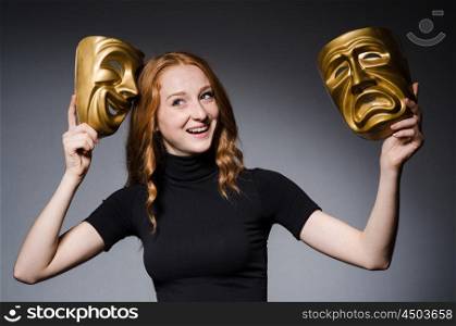 Redhead woman iwith masks in hypocrisy consept against grey background