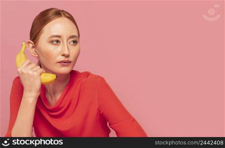 redhead woman using banana as telephone