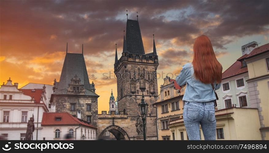 Redhead woman walking along the Charles Bridge in Prague