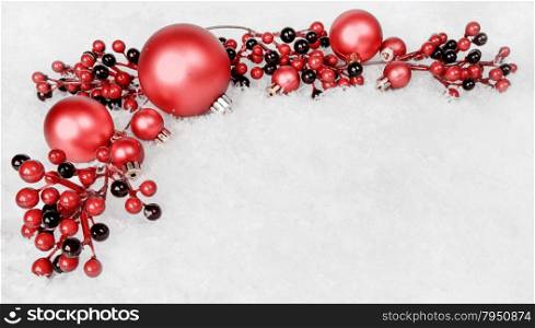 Reds Christmas balls and holly berries on white snow