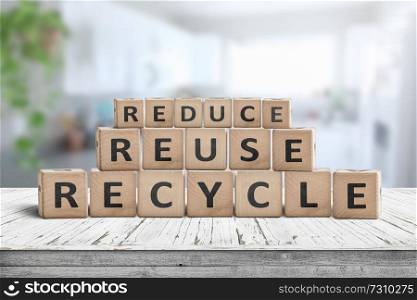 Reduce, reuse and recycle sing on a wooden desk woth a fresh bright background
