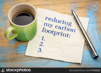 reducing my carbon footprint list - handwriting on a napkin with a cup of espresso coffee