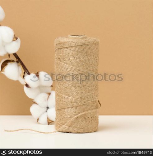 reel with brown rope on a white table, packing material, zero waste